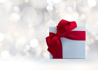 red ribbon bow gift box with elegant lighted background holiday, winter