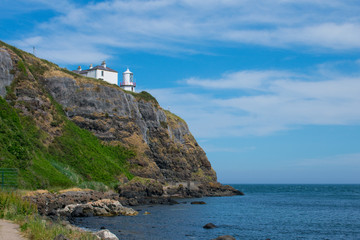 Fototapeta na wymiar low angle view on lighthouse on edge of cliff in whitehead northern Ireland 