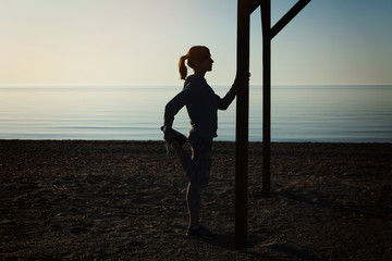 Young girl making yoga exercises at the sea beach