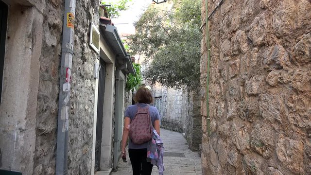 Tourist girl at the narrow cobbled street of the Budva Old town. Montenegro