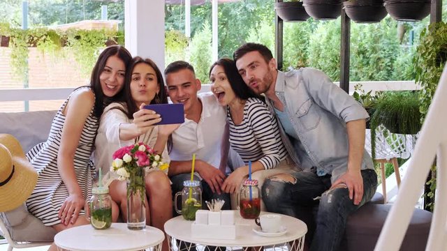 Group of friends makes selfie in at cafe