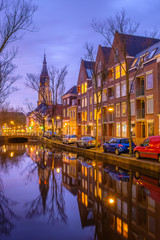 Fototapeta na wymiar Evening view of the canal and the church in Delft. Dutch city in the spring after sunset. Holland, Netherlands.