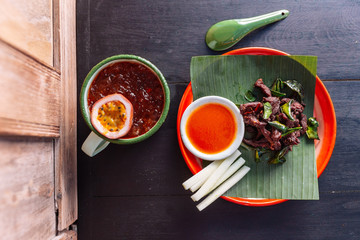 Neur Dad Diew (Thai Fried Sun-Dried Beef) with chili sauce served on zinc plate and spoon with iced passion fruit juice.