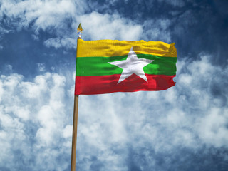 Myanmar flag Silk waving flag of Myanmar made transparent fabric with wooden flagpole gold spear on background sunny blue sky white smoke clouds real retro photo Countries of world 3d illustration