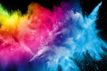 Abstract multi color powder explosion on black background.  Freeze motion of color dust  particles...