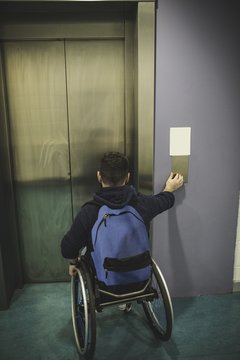 Handicapped man pressing button of elevator
