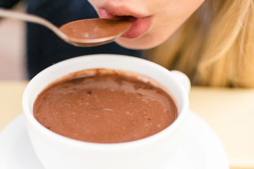The girl is eating hot chocolate