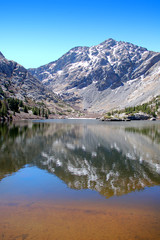Fototapeta na wymiar Craggy 14000 foot mountain peaks reflected in the waters of South Crestone lake in the Sangre De Cristo Mnts of Southern Colorado.