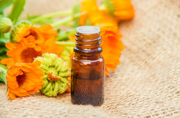 calendula extract and flowers in a small bottle. 
