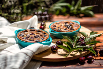 French cuisine. Clafoutis. Homemade cake. French cherry pie. On a wooden background.