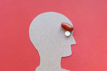 The man's head from paper eyes pills knit his brow in a red background, the emotion of...