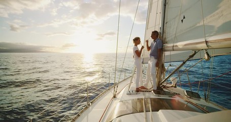 Middle aged couple celebrating life, sailing into the sunset