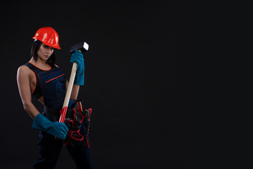 Sex equality and feminism. Sexy girl in safety helmet holding hammer tool. Attractive woman working...