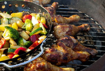 Barbecue / Grillparty im Sommer mit gegrillten Hähnchenkeulen und gemischtem Gemüse auf Holzkohlegrill  - 211817913
