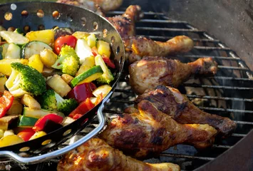 Gardinen Barbecue / Grillparty im Sommer mit gegrillten Hähnchenkeulen und gemischtem Gemüse auf Holzkohlegrill  © bidaya