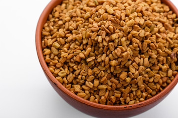 fragrant grains of fenugreek on a white background