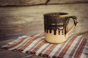clay mug with a towel on a wooden bench
