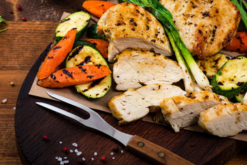 Grilled Chicken Breasts with Grilled Vegetables Zucchini and Carrot Background. Selective focus.