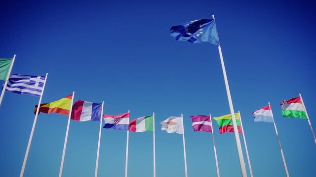 Flags of European Union and european countries against the blue sky. Smooth slowmotion from a 120 fps original shoot