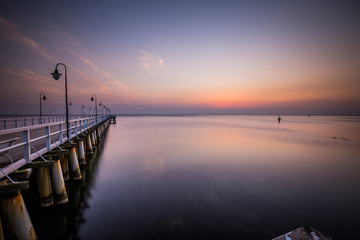 Fototapeta na wymiar Amazing colorful sunrise over the pier in Gdynia Orlowo. Sunrise over the sea.