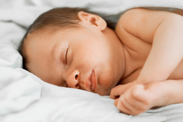 Fototapeta na wymiar Portrait of a sleeping newborn baby sleeping on his side