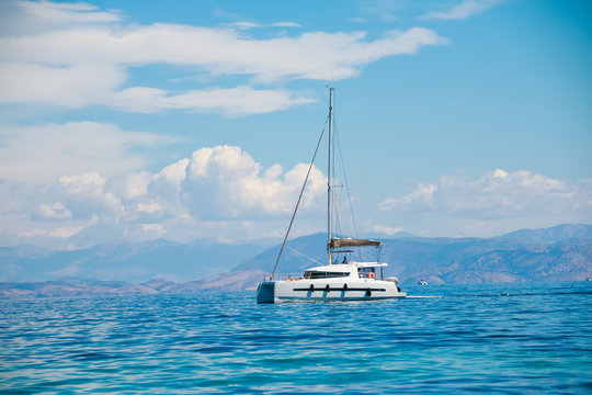 Asingle catamaran in the open sea.Sailboat in the Mediterranean Sea.catamaran sailing boat near coast.catamaran sail boat docked in tropical clear waters.Copy space