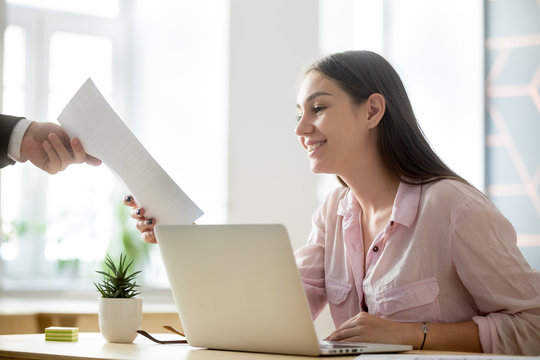 Satisfied female company intern happy to see good work results, receiving document report from employer, student get high evaluated sheet, excited to see professional growth and success