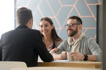 Happy millennial couple exited to buy first house together, consulting about apartment purchase in...