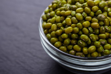 fresh Mung beans on a dark stone background