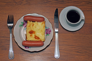 breakfast: sausages with an omelette and a cup of hot coffee