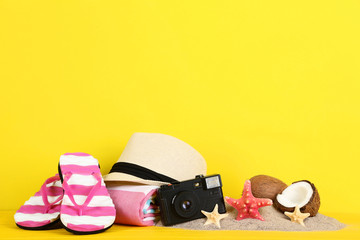 Summer accessories with starfishes and coconuts on yellow background
