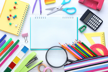 School supplies with blank sheet of paper on wooden table