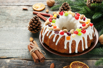 Bundt cake with fir-tree branches and cinnamon on wooden table