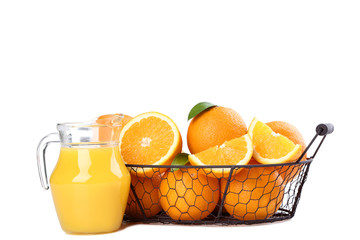 Orange fruit in basket with jug of juice isolated on white background