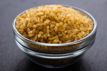 raw bulgur on a dark stone background
