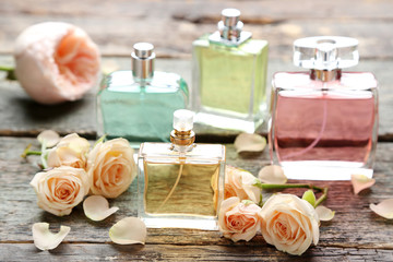 Obraz na płótnie Canvas Perfume bottles with roses on wooden table