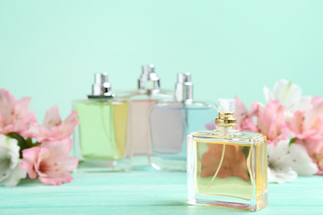 Obraz na płótnie Canvas Perfume bottles with flowers on wooden table