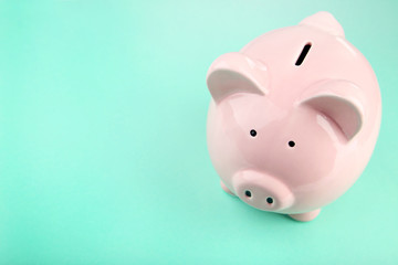 Pink piggy bank on mint background