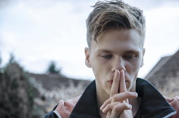 Sad depressed teenager pensive, hand over mouth looking down 