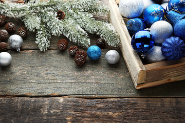 Blue and silver christmas baubles in crate with fir-tree branches