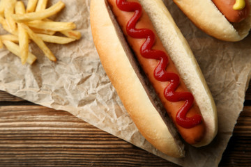 Hot dog with ketchup and french fries on wooden table