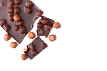 Chocolate pieces with hazelnuts on white background