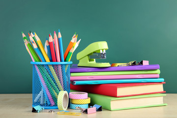 School supplies with books and notebooks on chalkboard background