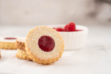 Traditional Christmas Linzer cookies with sweet jam on plate, closeup, copy space.
