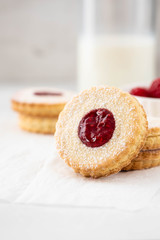 Traditional Christmas Linzer cookies with sweet jam on plate, closeup, copy space.