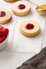 Traditional Christmas Linzer cookies with sweet jam on plate, closeup, copy space.