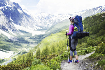 Trek around Mont Blanc. The girl is walking along the trail with a backpack.