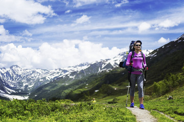 Trek around Mont Blanc. The girl is walking along the trail with a backpack.