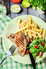 Grilled chicken breasts served with fries