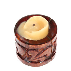 Burnt candle in a small old cylindrical wooden candlestick isolated on a white background